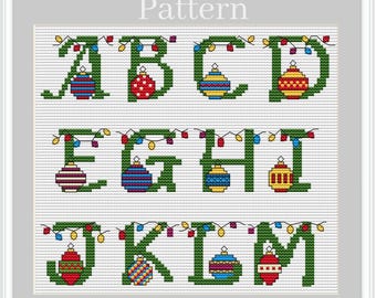 May include: Cross-stitch pattern featuring the alphabet letters A through M, each decorated with Christmas ornaments and string lights. The letters are green, and the ornaments are red, blue, yellow, and white. The word "Pattern" is at the top.