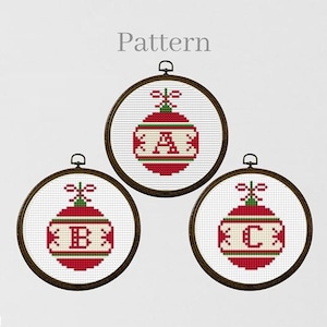 Może przedstawiać: Trzy wzory haftu krzyżykowego świątecznych ozdób w kolorze czerwonym i białym z literami A, B i C w środku każdej ozdoby.