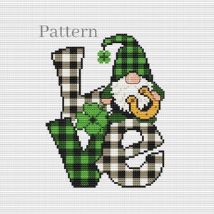 Puede incluir: Patrón de punto de cruz con la palabra "LOVE" y un diseño de gnomo. Las letras están en un patrón de cuadros blancos y negros, con la "O" que incorpora un gnomo que sostiene una herradura y tréboles. El gnomo lleva un gorro a cuadros verdes.