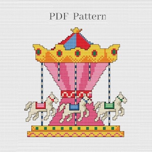 May include: A colorful cross-stitch pattern of a carousel with three horses. The carousel is pink, yellow, and blue with a gold crown on top. The horses are white with pink, blue, and green saddles.