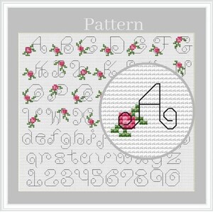 Pode incluir: Padrão de ponto cruz com o alfabeto e números, cada letra e número é decorado com uma rosa rosa e folhas verdes. A palavra "Pattern" está no topo.