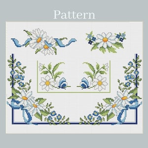 Op de afbeelding: Een kruissteekpatroon met het woord Pattern bovenaan. Het ontwerp bevat witte madeliefjes met gele harten, groene bladeren, kleine blauwe bloemen en blauwe linten, gerangschikt in diverse decoratieve hoek- en randmotieven.