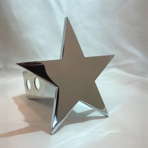May include: Chrome-plated star-shaped hitch cover. The cover has two holes for attaching to a trailer hitch.