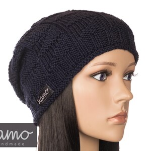 Peut inclure: Un bonnet en tricot bleu marine avec une petite &eacute;tiquette noire qui dit "siamo handmade".