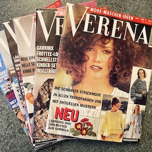 Puede incluir: Una pila de revistas Verena, con patrones de tejido. Las portadas muestran a una mujer con cabello rizado y texto en alemán. Las revistas exhiben varios proyectos de tejido con diseños coloridos y la palabra "NEU".