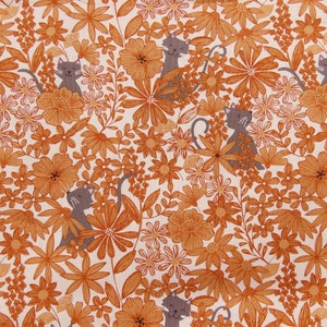 K&ouml;nnte beinhalten: Ein wei&szlig;er Stoff mit einem sich wiederholenden Muster aus orangefarbenen Blumen und grauen Katzen. Die Katzen sitzen in den Blumen und haben die Augen geschlossen.