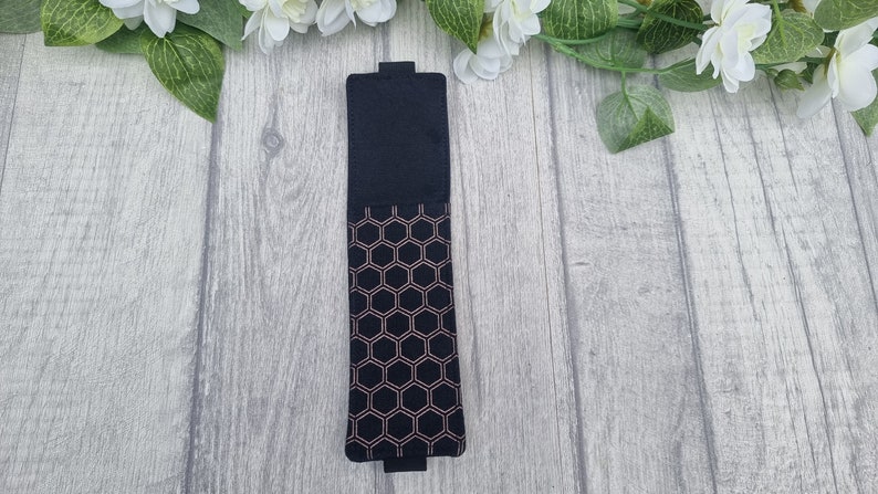 May include: A black felt bookmark with a rose gold honeycomb pattern.
