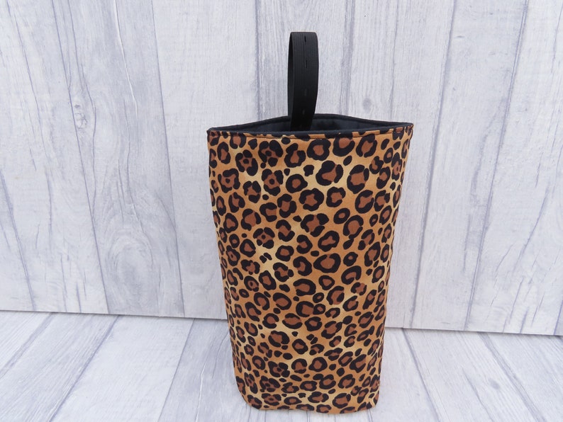 Puede incluir: Una bolsa de almacenamiento de tela con estampado de leopardo con un asa negra. La bolsa est&aacute; hecha de una tela suave y duradera y es perfecta para guardar objetos peque&ntilde;os.