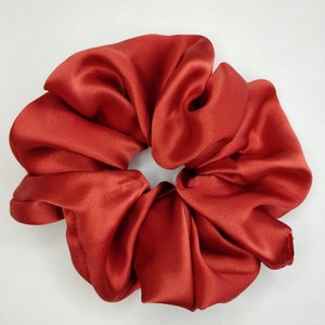 May include: A rust-colored satin scrunchie hair tie.