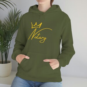 May include: A green hoodie with a gold crown and the word "Notary" in a cursive font.