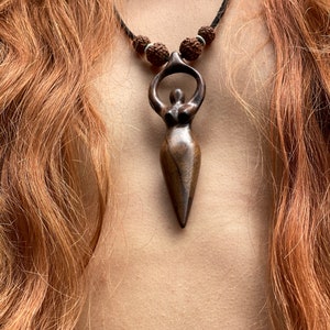 Handcrafted carved wood Artemis goddess amulet on a natural wood bead necklace, an ideal one-year anniversary gift symbolizing protection and shamanic tradition