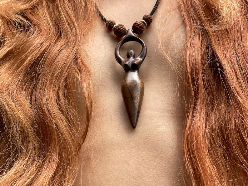 Handcrafted carved wood Artemis goddess amulet on a natural wood bead necklace, an ideal one-year anniversary gift symbolizing protection and shamanic tradition