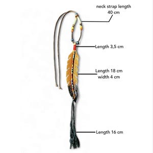 Op de afbeelding: Een kralen festival ketting met een lederen sjamaan amulet en een veer-vormige hanger. De nekband is 40 cm lang. De bovenkant van de hanger is 3,5 cm, de veer is 18 cm lang en 4 cm breed, en de franje onderaan is 16 cm. Tekst: LEATHER SHAMAN AMULET BEADED FESTIVAL NECKLACE.