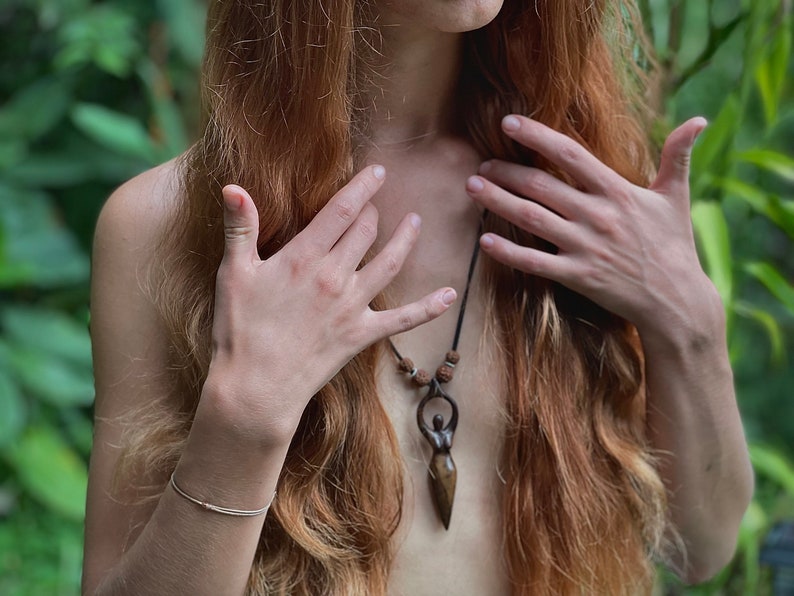 Handcrafted carved wood Artemis goddess amulet on a natural wood bead necklace, an ideal one-year anniversary gift symbolizing protection and shamanic tradition