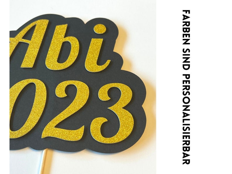 May include: Black and gold glitter paper cutout of "Abi 2023" for a graduation party.