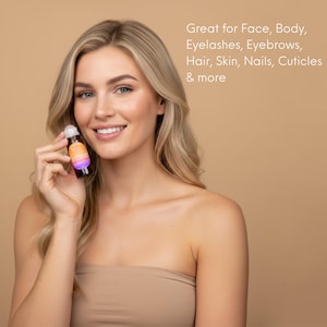 May include: A woman holds a small, colorful bottle with a white cap. The bottle has a label with orange and purple hues. Text on the image reads: Great for Face, Body, Eyelashes, Eyebrows, Hair, Skin, Nails, Cuticles & more.