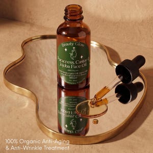 Pu&ograve; includere: Una bottiglia di vetro marrone di Beauty Glow Paracress, Castor & Jojoba Face Oil con un contagocce su uno specchio con bordo dorato. L'etichetta &egrave; verde con testo bianco e una silhouette. Il testo "100% Organic Anti-Aging & Anti-Wrinkle Treatment" &egrave; in basso.