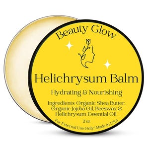 Op de afbeelding: Een ronde, open container met Beauty Glow Helichrysum Balm. Het gele etiket toont de productnaam, een bloemenillustratie en de tekst "Hydraterend & Voedend". Ingrediënten zijn sheaboter, jojoba-olie, bijenwas en essentiële helichrysumolie. De container bevat 57 gram.