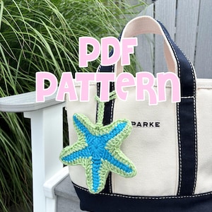 May include: A cream tote bag with navy blue trim and handles, and a green and blue crocheted starfish charm. The text "PDF PATTERN" is overlaid on the image. The bag is on a grey wooden chair.