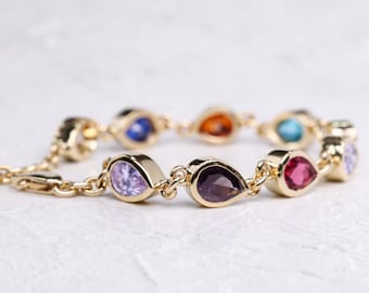Pulsera con engaste de bisel y múltiples piedras de nacimiento talla pera, oro amarillo de 14 quilates, ideal para bodas.