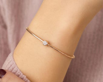 Pulsera de oro macizo de 14k con diamante solitario engastado en bisel y cadena fina de corte redondo.