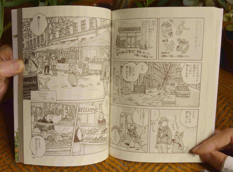 Puede incluir: Una p&aacute;gina de manga en blanco y negro con ilustraciones de personas y animales en un entorno urbano. El texto del manga est&aacute; en japon&eacute;s. El manga est&aacute; abierto a una p&aacute;gina con el texto "BIO!" y "sebr&uuml;he".