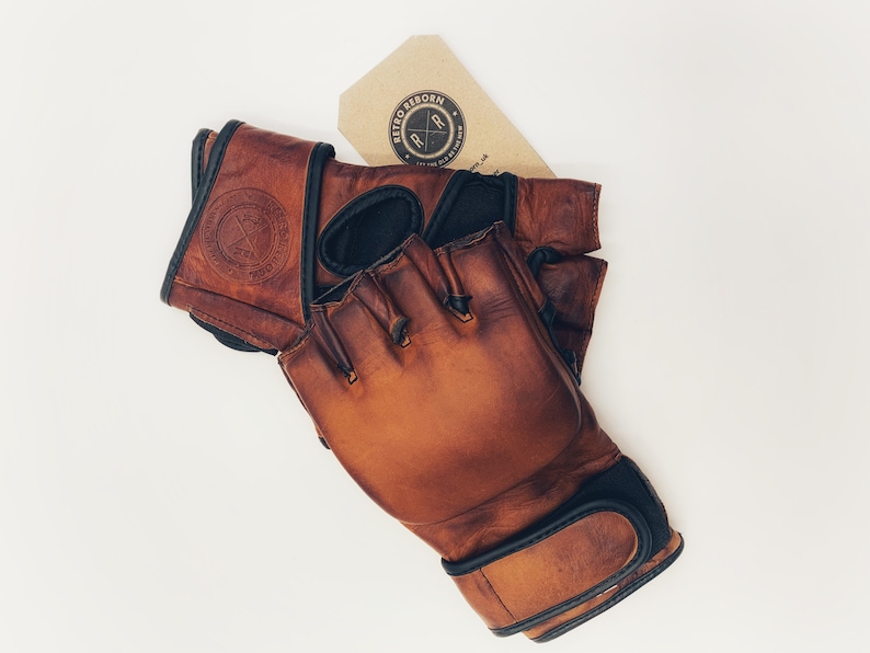 May include: Brown leather boxing gloves with black accents and a logo that says "Retro Reborn" on the wrist strap.