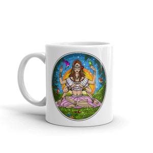 Puede incluir: Taza de cer&aacute;mica blanca con una colorida ilustraci&oacute;n de una mujer con m&uacute;ltiples brazos en meditaci&oacute;n. El dise&ntilde;o incluye p&aacute;jaros, flores y un sol, dentro de un marco circular. La taza tiene un asa curva.