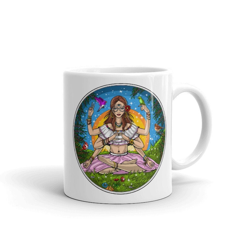 Puede incluir: Taza de cer&aacute;mica blanca con una colorida ilustraci&oacute;n de una mujer con m&uacute;ltiples brazos en posici&oacute;n de meditaci&oacute;n. El dise&ntilde;o incluye una puesta de sol, p&aacute;jaros y un borde de bosque. La taza tiene un asa est&aacute;ndar.