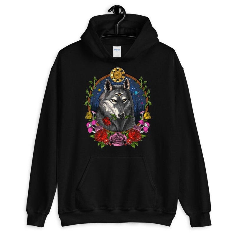 K&ouml;nnte beinhalten: Schwarzer Kapuzenpullover mit einem grafischen Aufdruck eines Wolfes mit drei Augen, umgeben von Blumen und einem himmlischen Hintergrund.