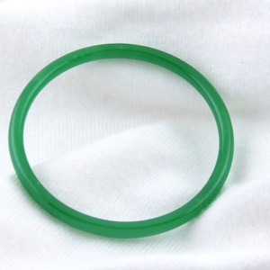 May include: A simple green bangle bracelet made of smooth, polished jade.