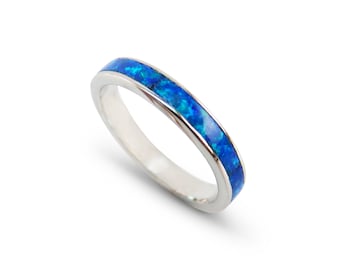 Pode incluir: Um anel de banda de prata com uma fina incrustação de opala azul.