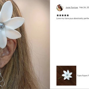May include: White foam flower with a pearl center, attached to a hair pick. The flower is worn in a woman's hair. The text "Love my tiare pua absolutely perfect! Maika! Highly recommend!" is visible in the image.