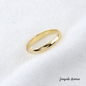 May include: A simple gold band ring.