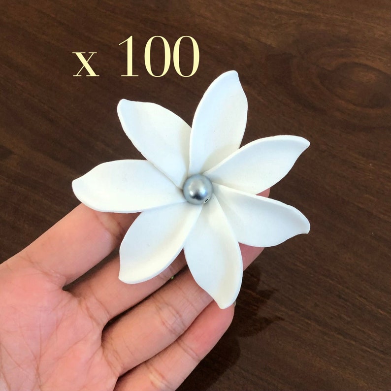May include: White paper flower with a silver pearl center. x 100