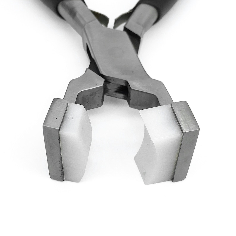 May include: Close-up of a pair of silver pliers with white rubber jaws. The pliers are open and the jaws are facing the camera.