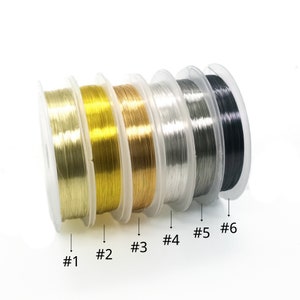 May include: Six spools of wire in different colors: gold, brass, silver, gray, and black. The spools are labeled #1 through #6.