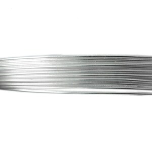 May include: Close-up of a bundle of silver-colored wire, tightly wound together. The wire appears to be made of a shiny, metallic material, and the individual strands are clearly visible. The background is plain white.
