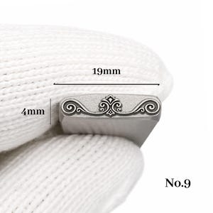Op de afbeelding: Een metalen stempel met een sierlijk krulontwerp, 19 mm breed en 4 mm hoog. De stempel heeft een centraal decoratief element en is gemarkeerd met "No.9".