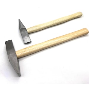Puede incluir: Dos martillos con mango de madera y cabezas de metal. El martillo más grande tiene una cabeza curva y el martillo más pequeño tiene una cabeza plana.
