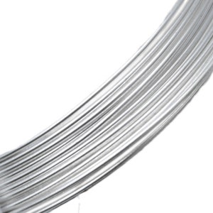 May include: Close-up of a bundle of shiny, silver-colored wire. The wire is tightly wound, creating a curved shape against a white background. The texture of the wire is smooth and reflective, suggesting a metallic material.