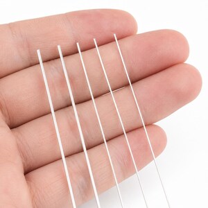 Pu&ograve; includere: Primo piano di diversi fili sottili, trasparenti e dritti. I fili sono tenuti in mano su sfondo bianco. I fili sembrano essere fatti di un materiale trasparente, forse plastica.