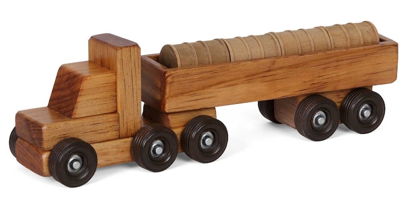 Pu&ograve; includere: Un camion giocattolo di legno con un rimorchio che trasporta tronchi. Il camion &egrave; marrone e ha ruote nere. Il rimorchio &egrave; anche marrone e ha ruote nere. I tronchi sono marroni e sono impilati nel rimorchio.