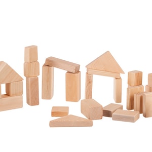 May include: A set of wooden building blocks in various shapes and sizes, including squares, rectangles, and triangles. The blocks are arranged in a loose pile on a white background.