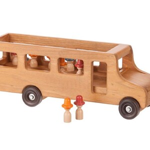 May include: A wooden toy bus with a brown finish and open windows. The bus has a driver's seat and a row of seats for passengers. There are small wooden figures with colorful hats standing in front of the bus.