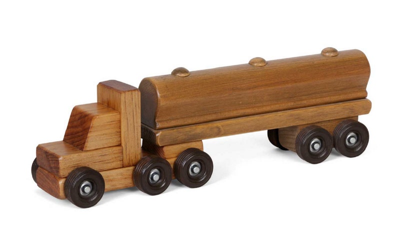 Pu&ograve; includere: Un camion giocattolo di legno con un rimorchio cisterna di legno marrone. Il camion ha quattro ruote e il rimorchio ne ha due. Il camion e il rimorchio sono fatti di legno naturale.