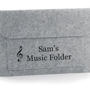 May include: A grey felt music folder with a treble clef and the text "Sam's Music Folder" printed on the front.