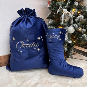 May include: A blue velvet Christmas stocking and a matching Santa sack with gold stars and the name "Ottilie" embroidered on them.