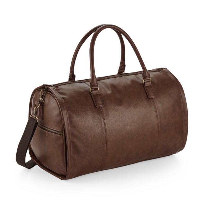 Pu&ograve; includere: Una borsa da viaggio in pelle marrone con manico superiore e tracolla. La borsa ha una chiusura a zip e un tiretto della zip dorato.