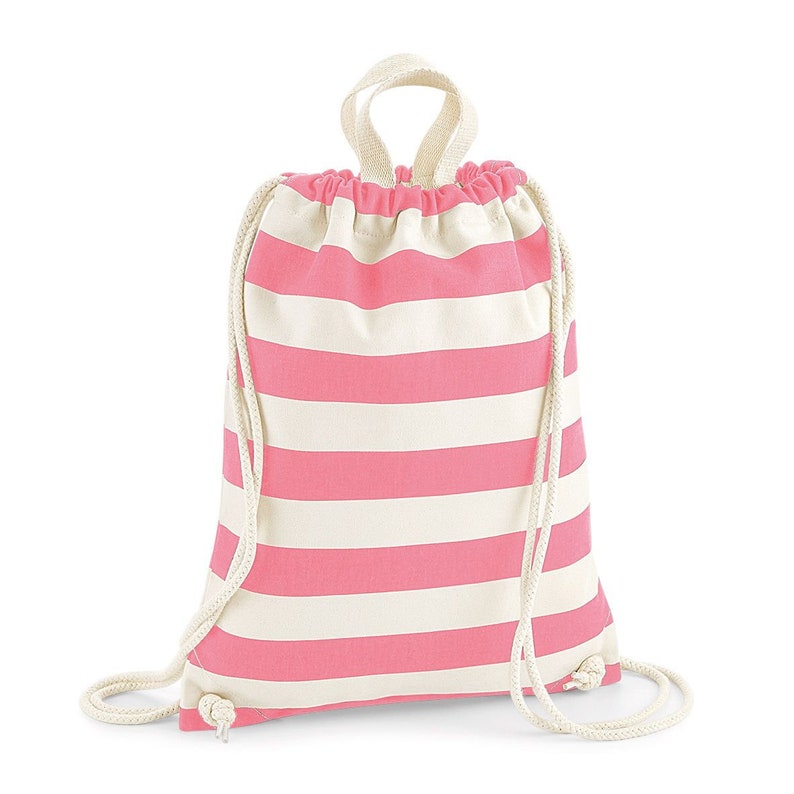 May include: A pink and white striped drawstring backpack. The bag has a cream-colored drawstring closure and a small loop handle at the top. The bag is made of a soft, durable fabric.